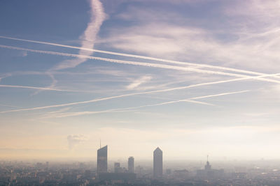 Aerial view of modern buildings in city against sky with air pollution