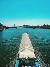 Bridge over sea against clear blue sky