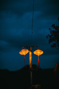 Low angle view of illuminated lights against sky at night