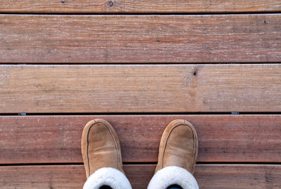 Low section of man standing on wooden floor