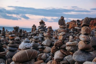 Stack of pebbles at beach against sky