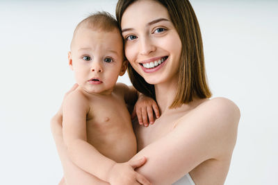 Portrait of naked woman against white background