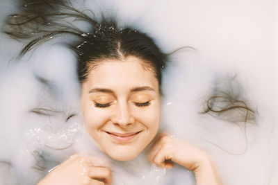 Portrait of a smiling young woman with eyes closed