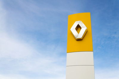 Low angle view of sign against blue sky