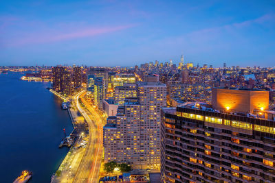 High angle view of illuminated cityscape against sky at night