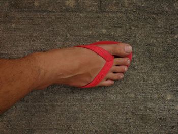 Low section of man wearing shoes on sand