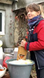 A woman prepares sauerkraut for the winter in autumn under the open sky