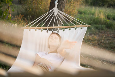 Midsection of woman lying on hammock