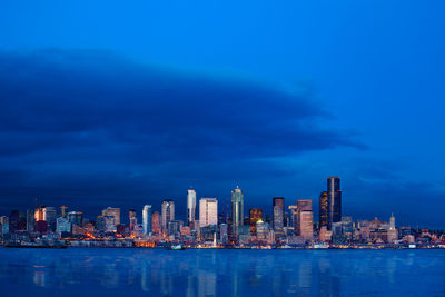 Illuminated buildings in city against sky