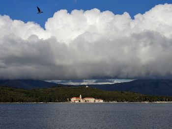 Scenic view of sea by buildings against sky