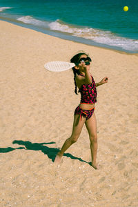 Girl in bikini playing matkot at beach