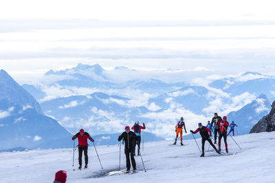 People skiing on snow covered landscape