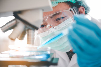 Close-up of doctor examining over microscope