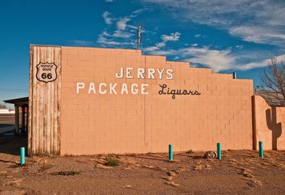 Text on brick wall against sky