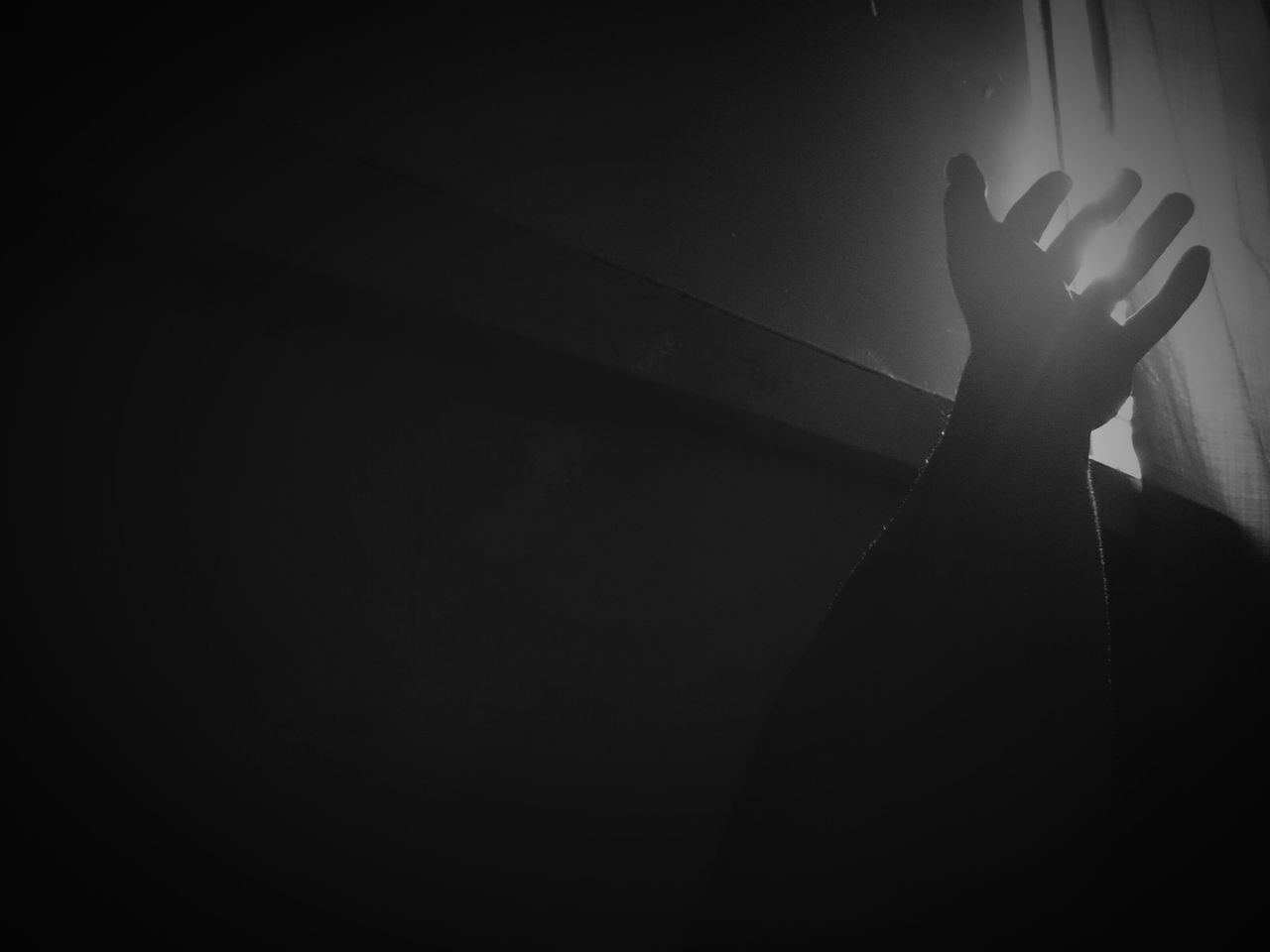 indoors, lifestyles, leisure activity, person, men, dark, unrecognizable person, shadow, part of, standing, silhouette, night, wall - building feature, copy space, holding, human finger