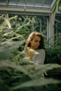A close up portrait of a young woman amidst plants