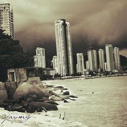 Skyscrapers against cloudy sky