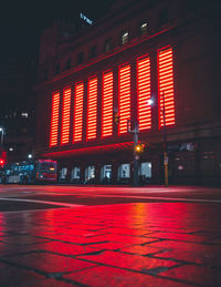 Illuminated city street and building at night