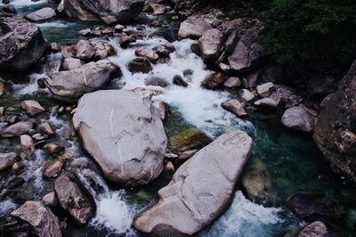 High angle view of stream flowing through rocks in river