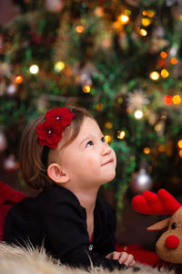 Girl looking away at illuminated christmas tree