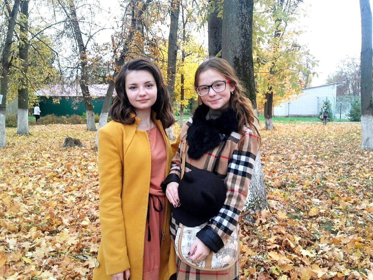 looking at camera, tree, portrait, togetherness, leisure activity, lifestyles, bonding, casual clothing, girls, standing, field, young women, friendship, tree trunk, person, day, young adult, outdoors