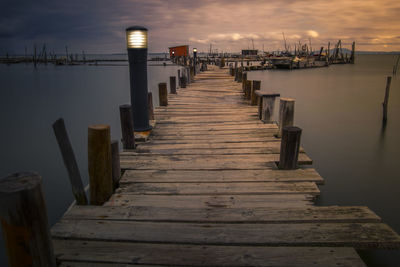 Wooden pier over sea against sky