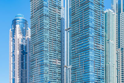 Low angle view of modern buildings against blue sky