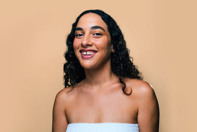 Portrait of young woman against pink background