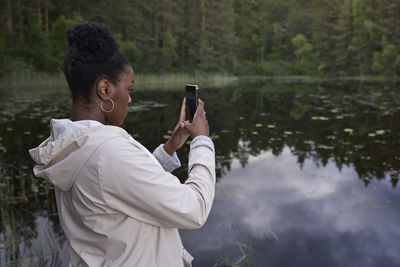 Young woman taking photo with cell phone