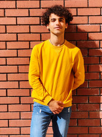 Young man standing against wall