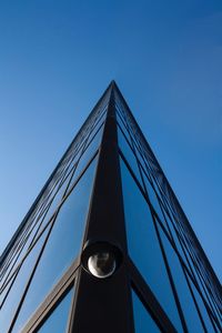 Low angle view of security camera on bridge against clear blue sky