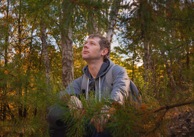 Man looking away in forest