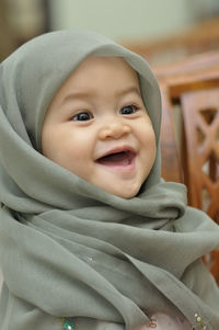Close-up of cheerful baby girl wearing hijab while looking away