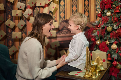 Rear view of two women sitting on christmas tree