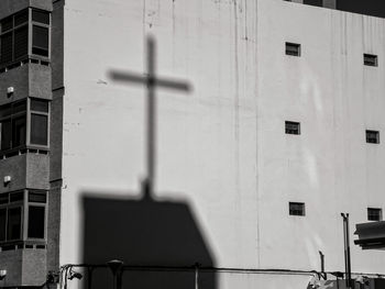 Low angle view of cross on building wall