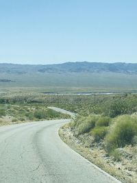 Road by landscape against clear sky