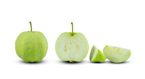 Close-up of fresh green fruits against white background