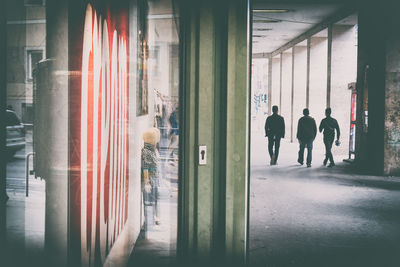 Rear view of men walking in corridor