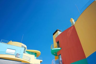 Low angle view of buildings against clear blue sky