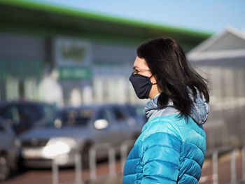 Side view of woman standing against blurred background