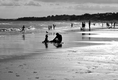People on beach against sky