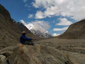 Man surfing on rock in mountains against sky