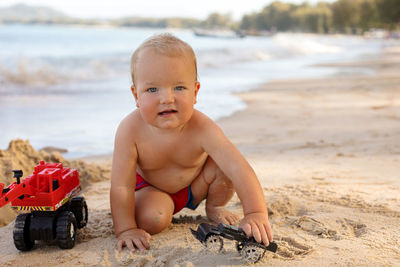 Cute boy with toy on beach