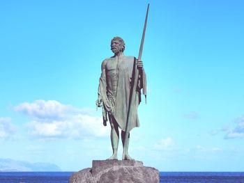 Low angle view of statue against sea and sky