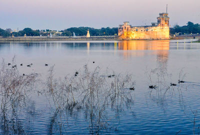 Scenic view of lake by buildings against sky