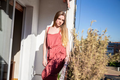 Beautiful young woman standing in front of building