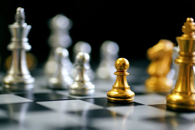 Close-up of chess board on table against black background