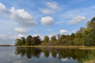 Scenic view of lake by trees against sky