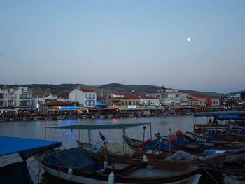 Boats moored in harbor against buildings in city