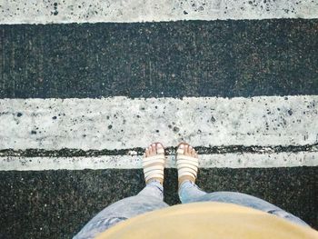 Low section of woman standing on road